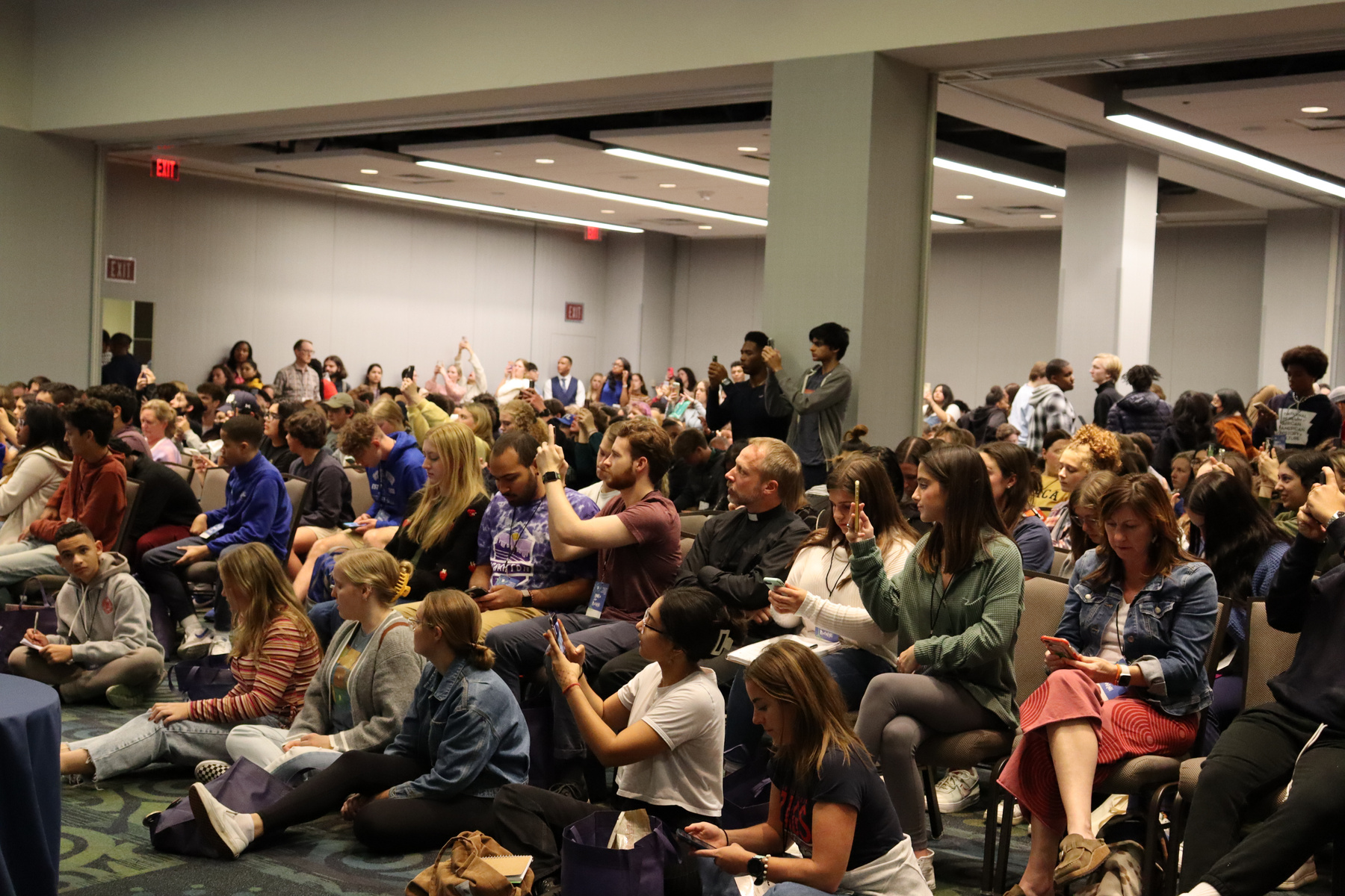 Hundreds of young Catholics take photos of CMN's panel presentation at the 2022 Ignatian Family Teach-In for Justice